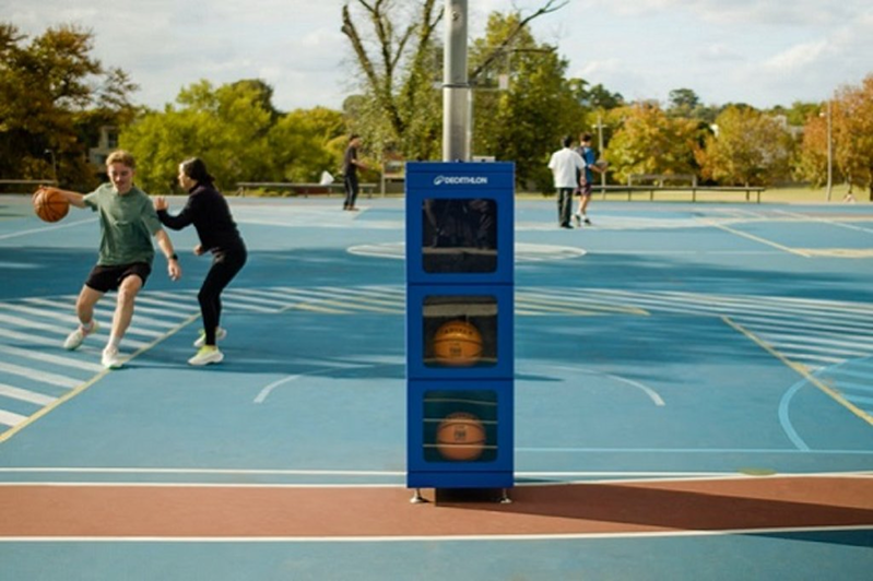 Kids playing soccer next to an Accessa recreation locker at a community park